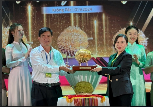 Bà Ngô Tường Vy (áo đen) nhận phần quà là quả sầu riêng lưu niệm mạ vàng sau khi đấu giá trúng quả sầu riêng tươi Ri6 - nữ hoàng sầu riêng - Ảnh: NLĐO Bà Ngô Tường Vy (áo đen) nhận phần quà là quả sầu riêng lưu niệm mạ vàng sau khi đấu giá trúng quả sầu riêng tươi Ri6 - nữ hoàng sầu riêng - Ảnh: NLĐO