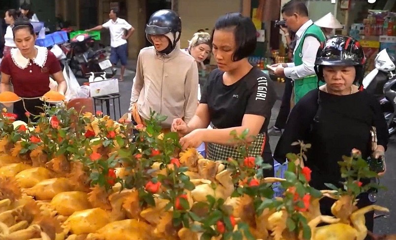 Nổi bật nhất giữa các gian hàng xôi, nem, giò chả... là những con gà ta luộc sẵn, da vàng óng ả, được tạo thế