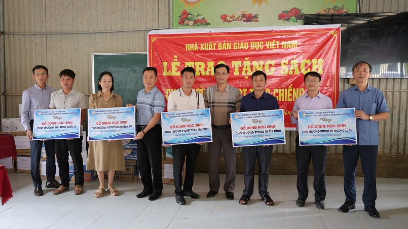 Ông Trần Quang Đức - Giám đốc Công ty CP Sách và Thiết bị trường học Điện Biên (ngoài cùng bên trái) trao tặng đồ dùng học tập cho các trường.