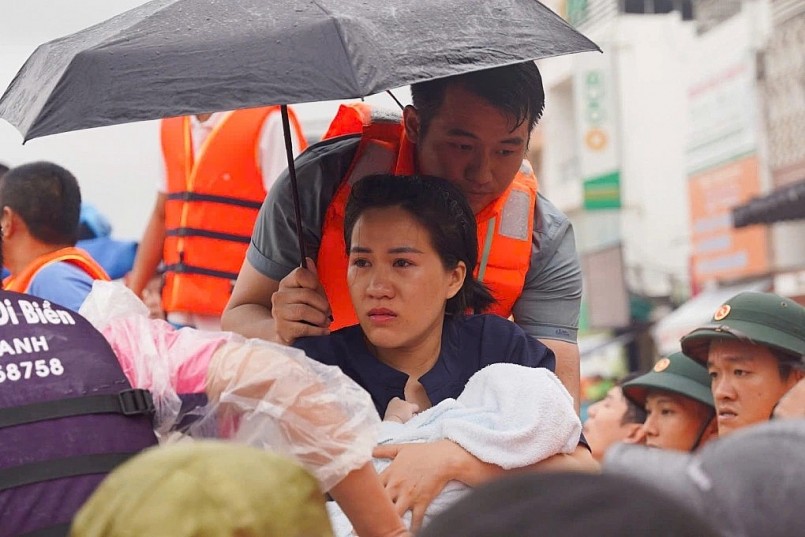 Người dân được lực lượng chức năng thoát khỏi dòng lũ xiết. Ảnh: Bùi Toàn